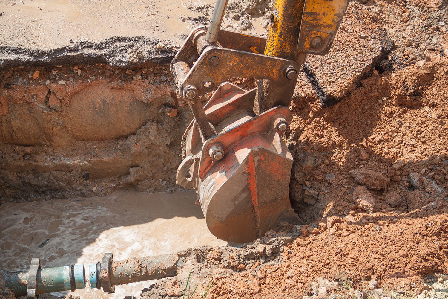 Excavator working around the underground pipe